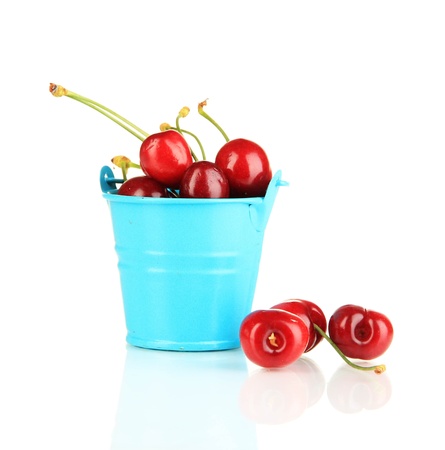 Ripe red cherry berries in pail isolated on whiteの写真素材