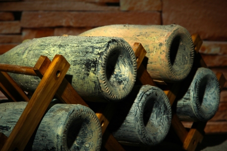 Old bottles of wine in old cellar, on dark  backgroundの写真素材