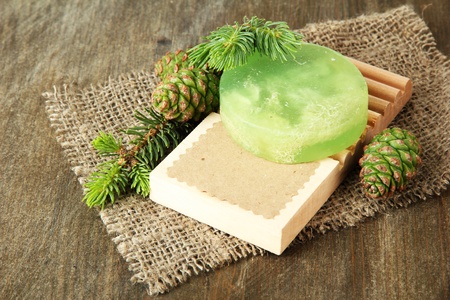 Hand-made soap and green pine cones on wooden backgroundの写真素材