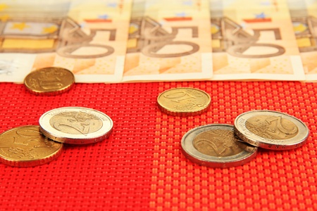 Euro banknotes and euro cents on red backgroundの写真素材
