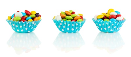 Colorful candies in cupcake cases isolated on white