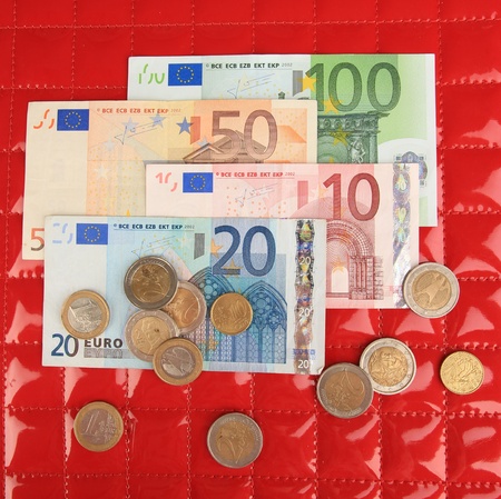 Euro banknotes and euro cents on red backgroundの写真素材