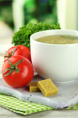 Cup of soup with bouillon cubes on wooden tableの写真素材