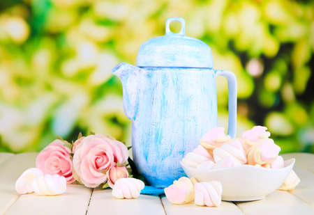 Antique white teapot on wooden table on natural backgroundの写真素材