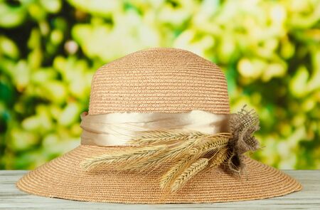 Beautiful summer hat with spikelets on green background