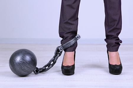 Business worker with ball and chain attached to footの写真素材