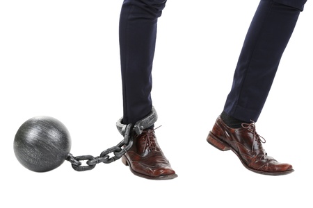 Business worker with ball and chain attached to foot isolated on white