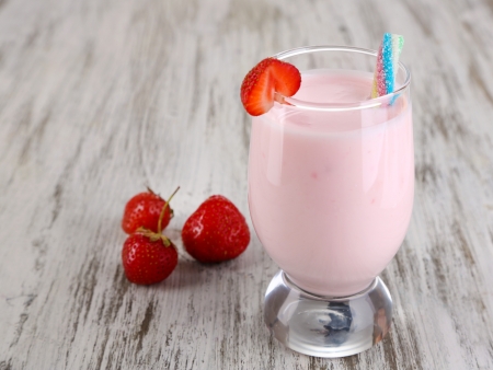 Delicious milk shake with strawberries on wooden table close-upの写真素材