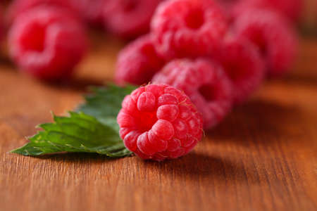 Ripe sweet raspberries on wooden background