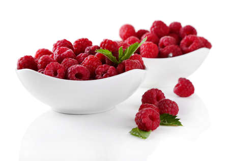 Ripe sweet raspberries in bowls, isolated on white
