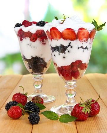 Natural yogurt with fresh berries on wooden table on green backgroundの写真素材