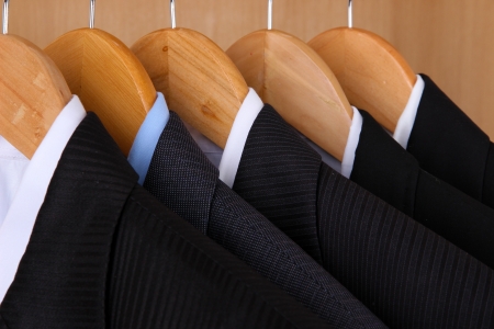 Suits with shirts on hangers on wooden backgroundの写真素材