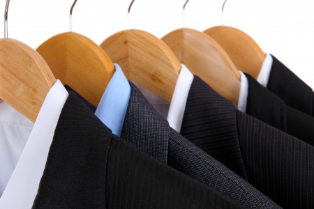 Suits with shirts on hangers on white backgroundの写真素材