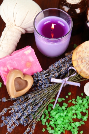 Still life with lavender candle, soap, massage balls, bottles,  soap and fresh lavender, on wooden  table on wooden backgroundの写真素材