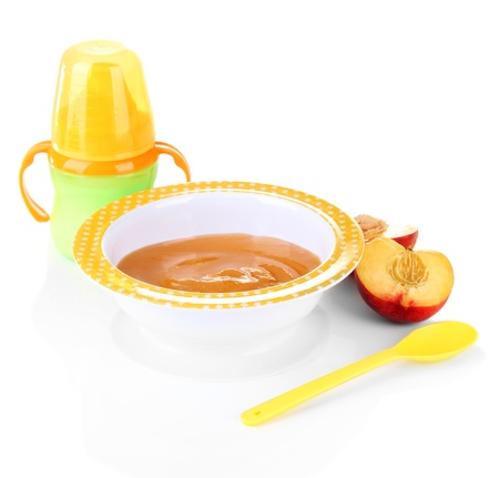 Tasty baby fruit puree and baby bottle isolated on whiteの写真素材