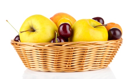 Bright summer fruits in basket isolated on whiteの写真素材