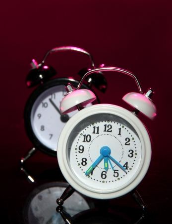 Two old style alarm clocks on dark color backgroundの写真素材