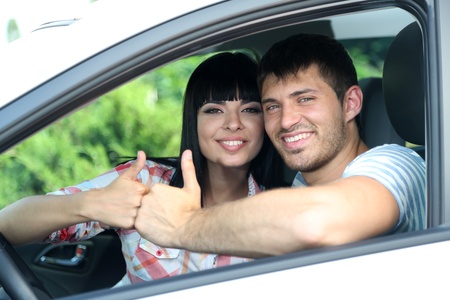 Beautiful happy young couple driving car