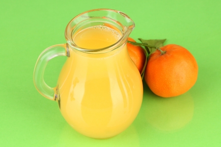 Full jug of orange juice, on wooden table on bright backgroundの写真素材