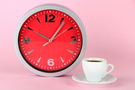 Cup coffee and clock on pink backgroundの写真素材