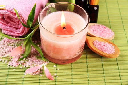 Beautiful spa setting with pink candle on bamboo matの写真素材