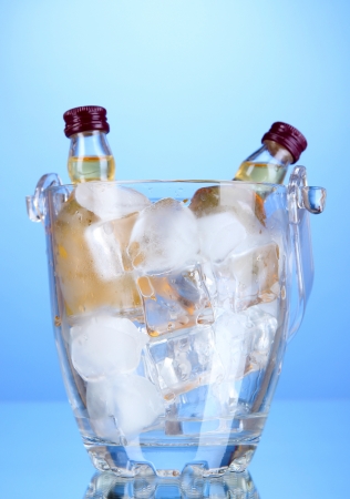 Minibar bottles in bucket with ice cubes,  on color backgroundの写真素材