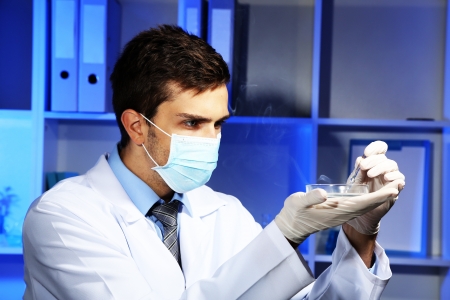 Young laboratory scientist with petri dish working at labの写真素材