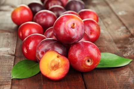 Ripe plums on wooden table close-upの写真素材