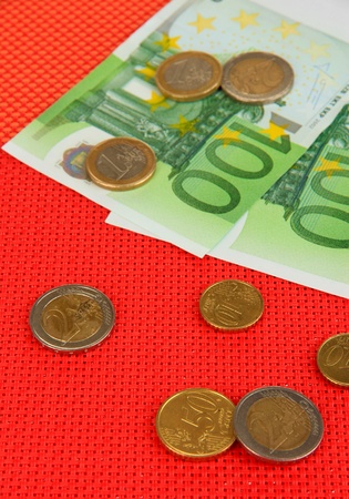 Euro banknotes and euro cents on red backgroundの写真素材