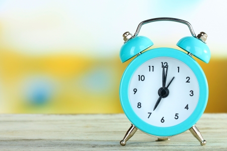 Alarm clock on table on bright backgroundの写真素材
