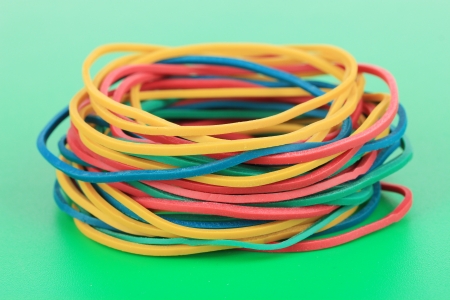 Colorful rubber bands on green backgroundの写真素材