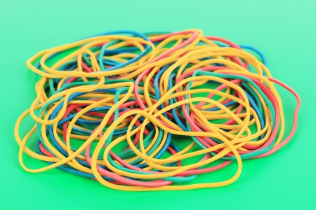 Colorful rubber bands on green backgroundの写真素材
