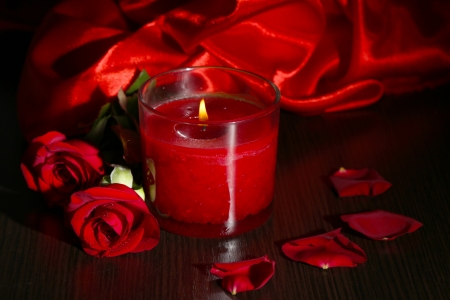 Beautiful romantic red candle with flowers and silk cloth, close upの写真素材