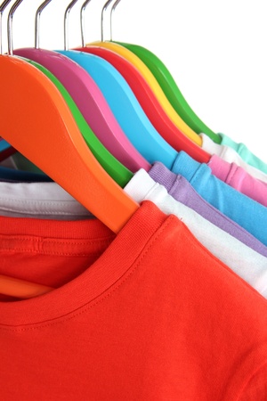 Different shirts on colorful hangers on white backgroundの写真素材
