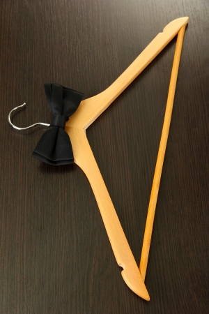 Black bow tie on wooden hanger, on wooden backgroundの写真素材