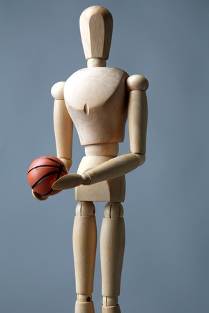 Wooden mannequin with basketball ball on grey backgroundの写真素材