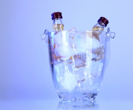 Minibar bottles in bucket with ice cubes,  on color backgroundの写真素材
