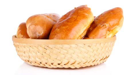 Fresh baked pasties in wicker basket, isolated on whiteの写真素材