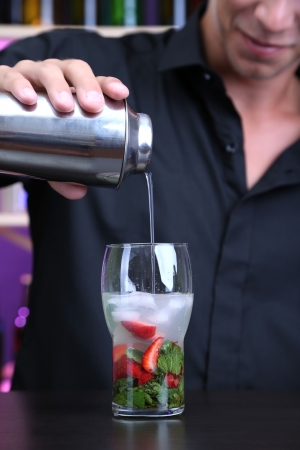 Portrait of handsome barman preparing cocktail, at barの写真素材
