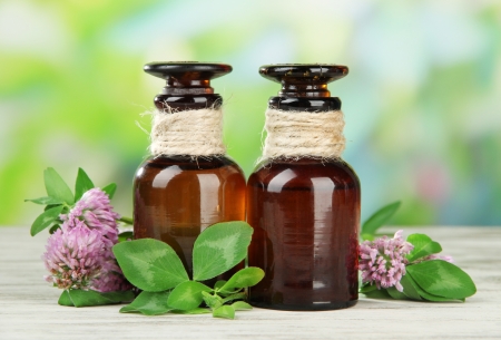 Medicine bottles with clover flowers on wooden table, outdoorsの写真素材