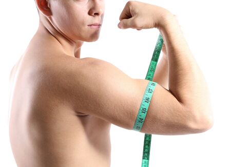 Handsome young muscular sportsman with measuring tape, isolated on whiteの写真素材