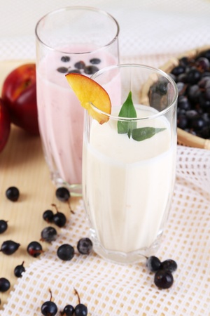 Delicious milk shakes with blackberry and peach on wooden table close-upの写真素材