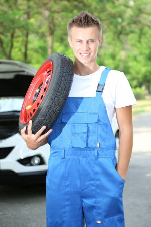 Auto mechanic with tire on his shoulderの写真素材