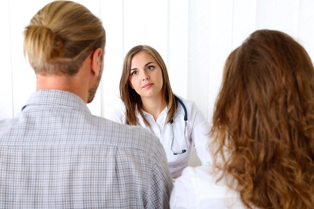 Doctor and young couple patients at officeの写真素材