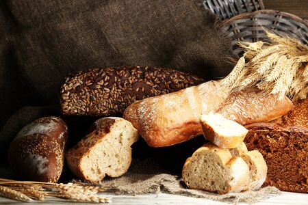 Much bread on wooden board on  wicker tray background