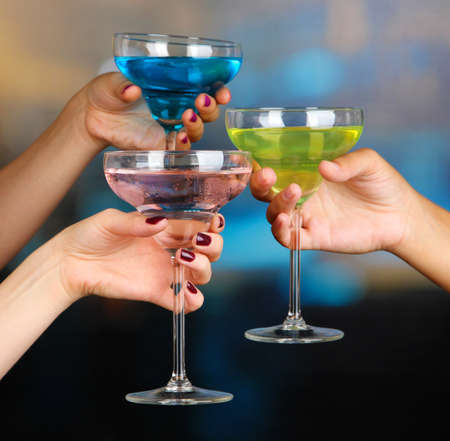 Cocktails in hands in nightclubの写真素材