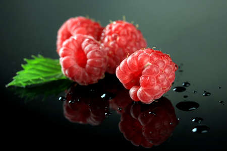 Ripe sweet raspberries with drops on dark backgroundの写真素材