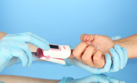 Pulse oximeter used to measure pulse rate and oxygen levels, on color backgroundの写真素材