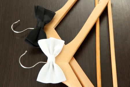 Black and white  bow ties on wooden hangers, on wooden backgroundの写真素材