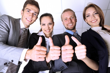 Business team showing thumbs up in officeの写真素材